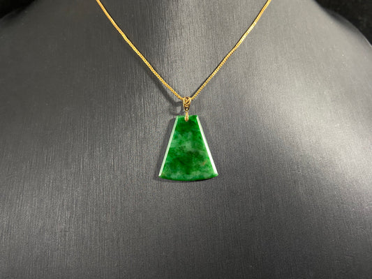 A light green jade plaque with darker green veining, featuring a gold plated 925 silver bail.