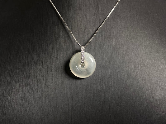A serene icy clear jade circle pendant, embodying lifelong harmony and peace in its graceful form.