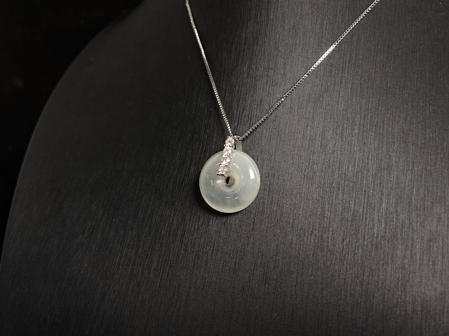 A serene icy clear jade circle pendant, embodying lifelong harmony and peace in its graceful form.