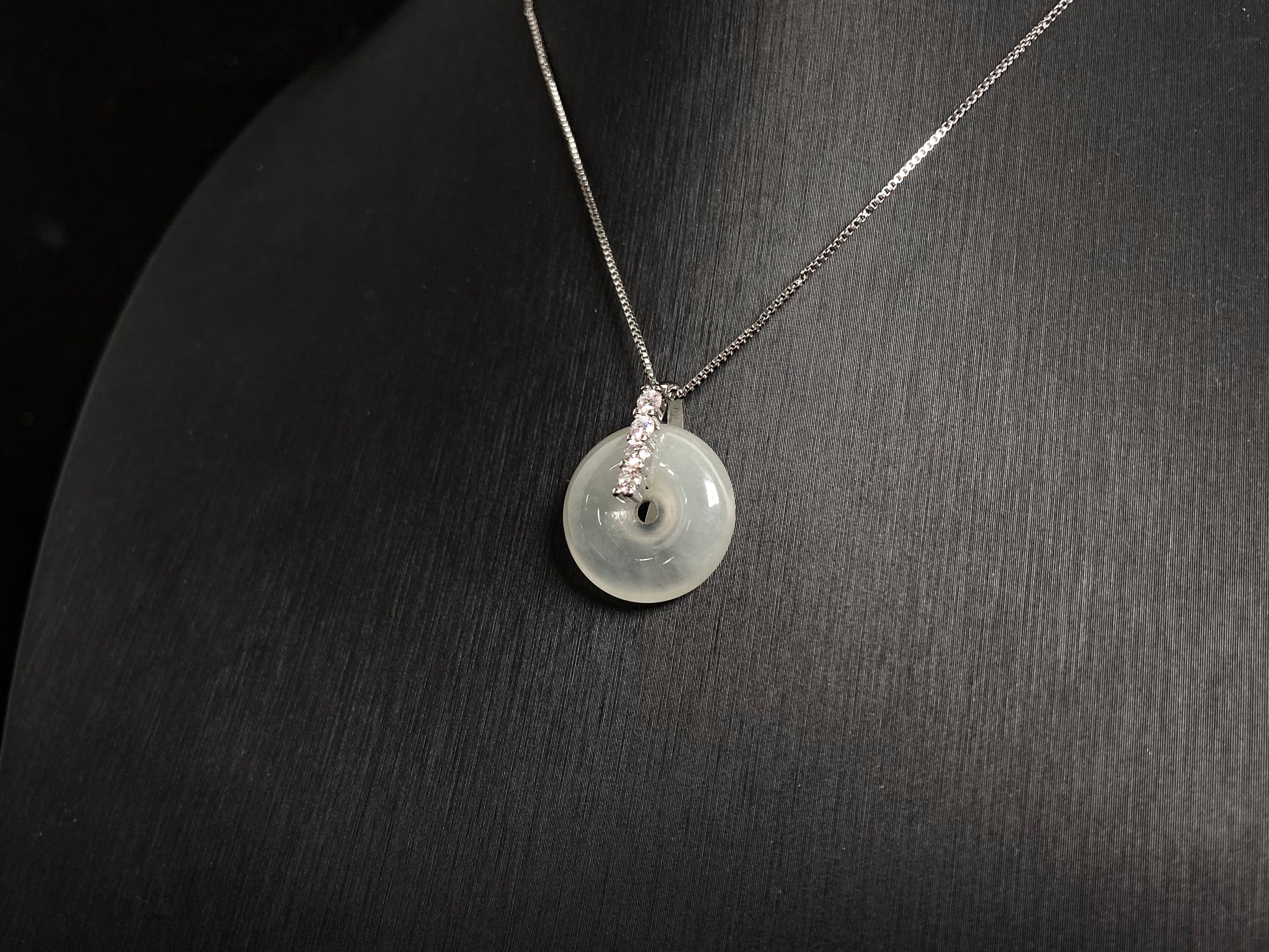 A serene icy clear jade circle pendant, embodying lifelong harmony and peace in its graceful form.