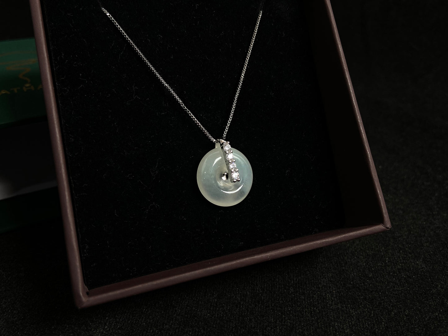 A serene icy clear jade circle pendant, embodying lifelong harmony and peace in its graceful form.