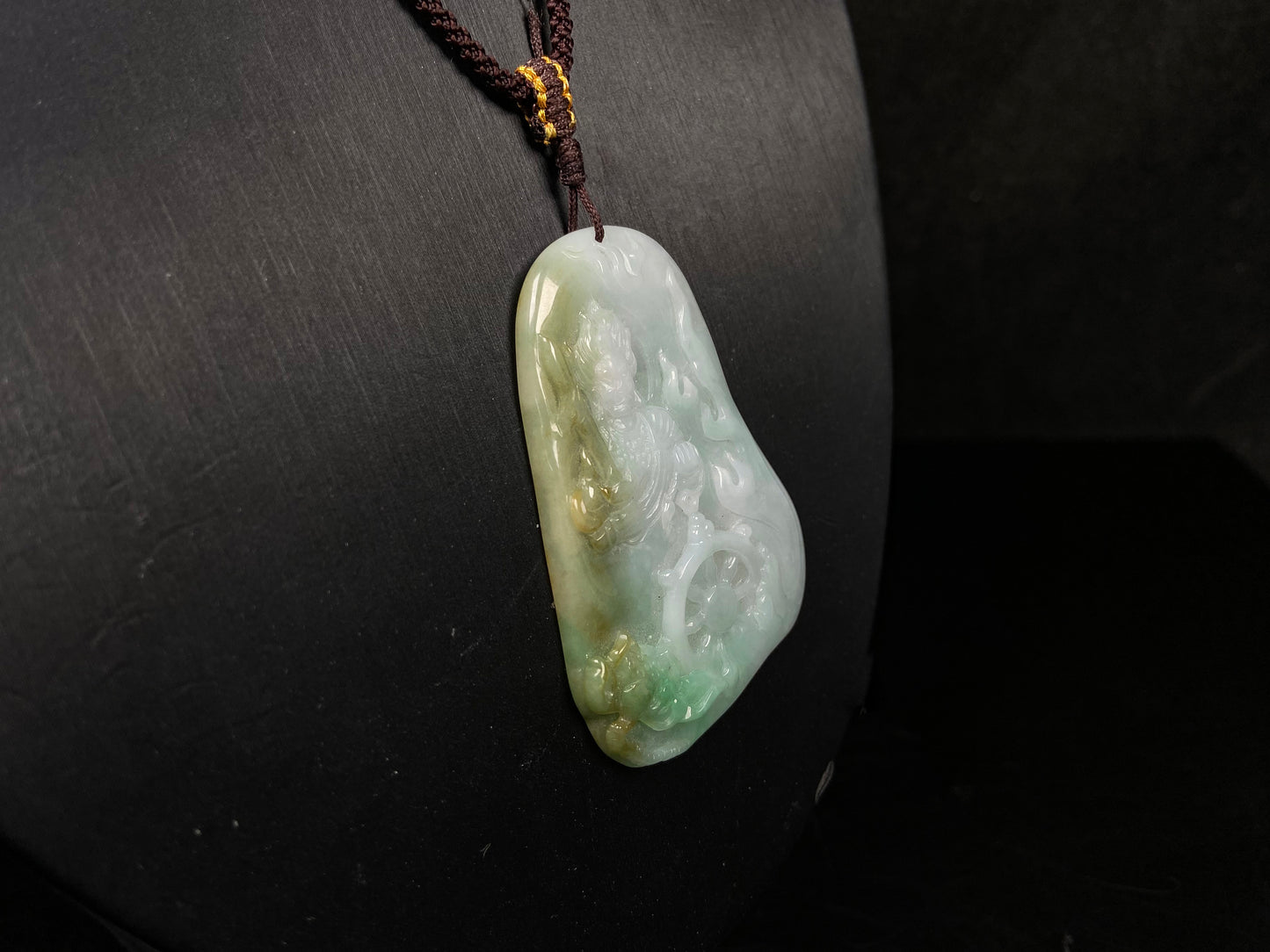A green-yellow bodhisattva with dharma wheel jadeite pendant.