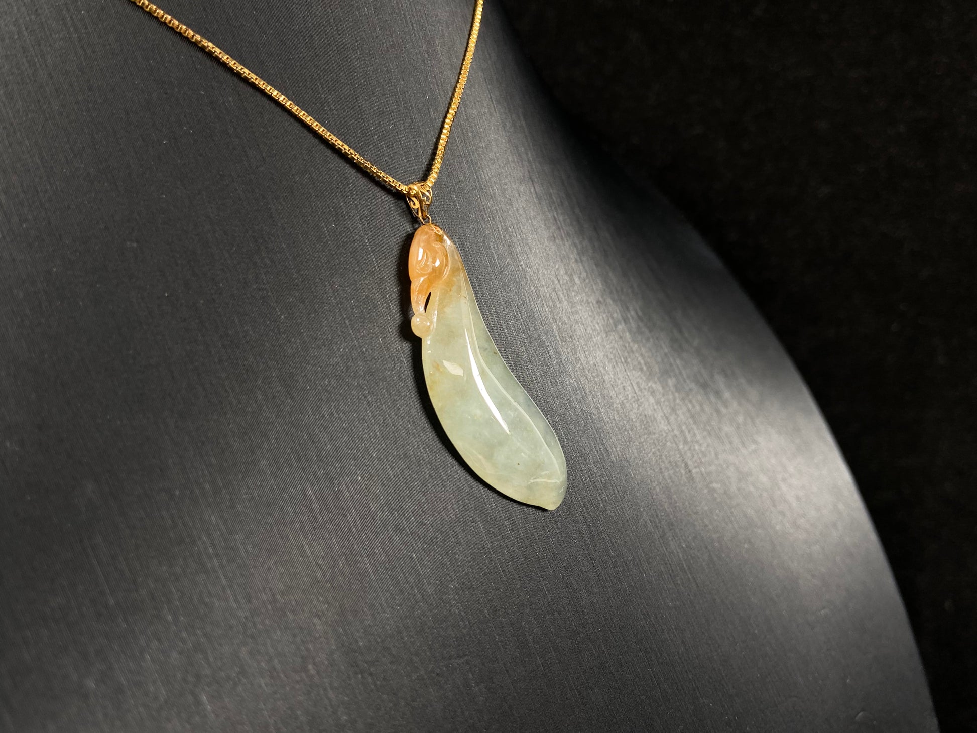An icy jadeite "Fu Gua" pendant with gold speckles.