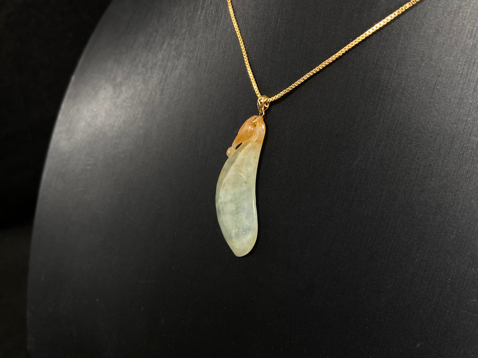 An icy jadeite "Fu Gua" pendant with gold speckles.