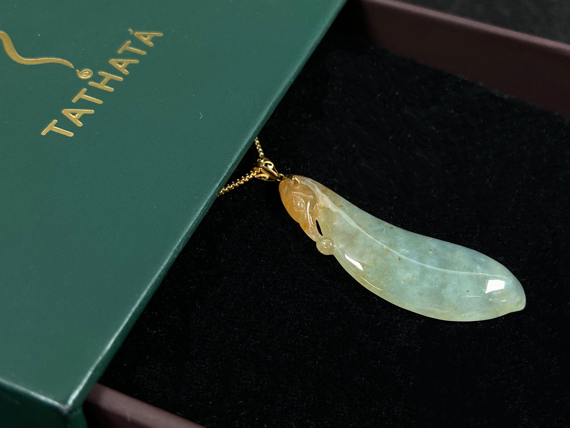 An icy jadeite "Fu Gua" pendant with gold speckles.