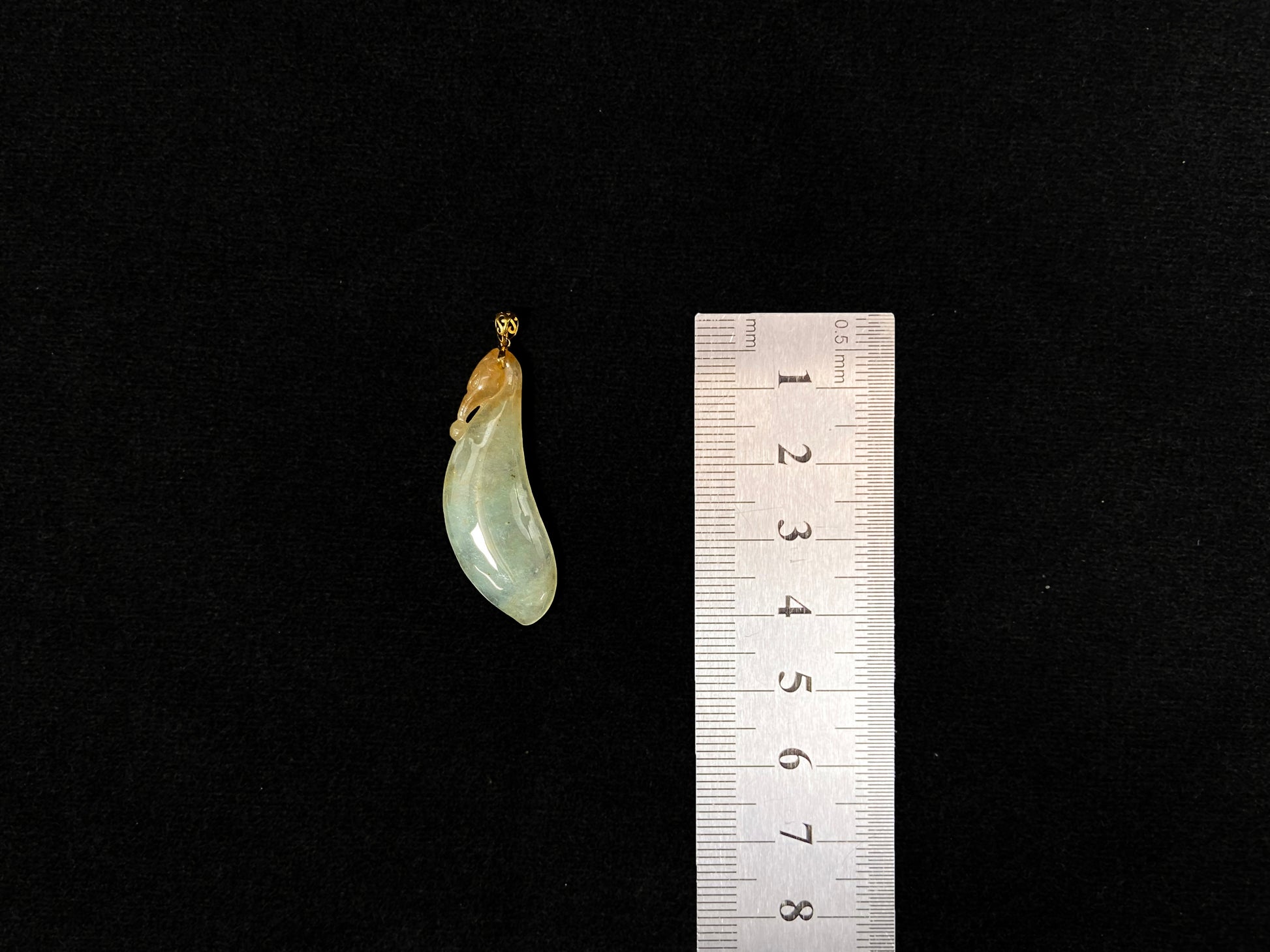 An icy jadeite "Fu Gua" pendant with gold speckles.