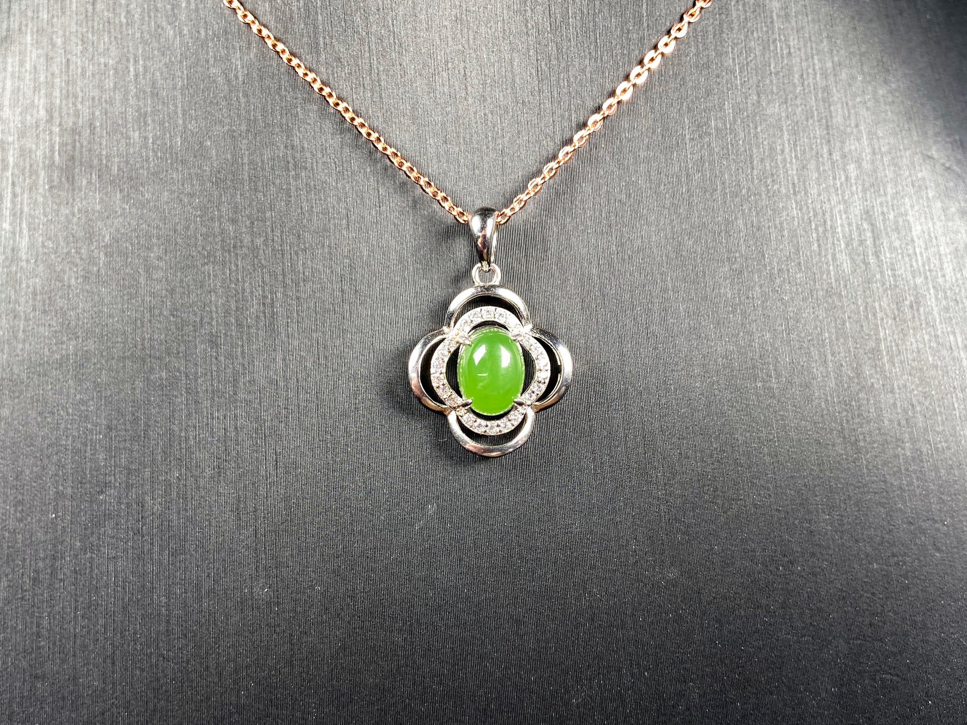 A vibrant clover green cabochon Hetian jade pendant.