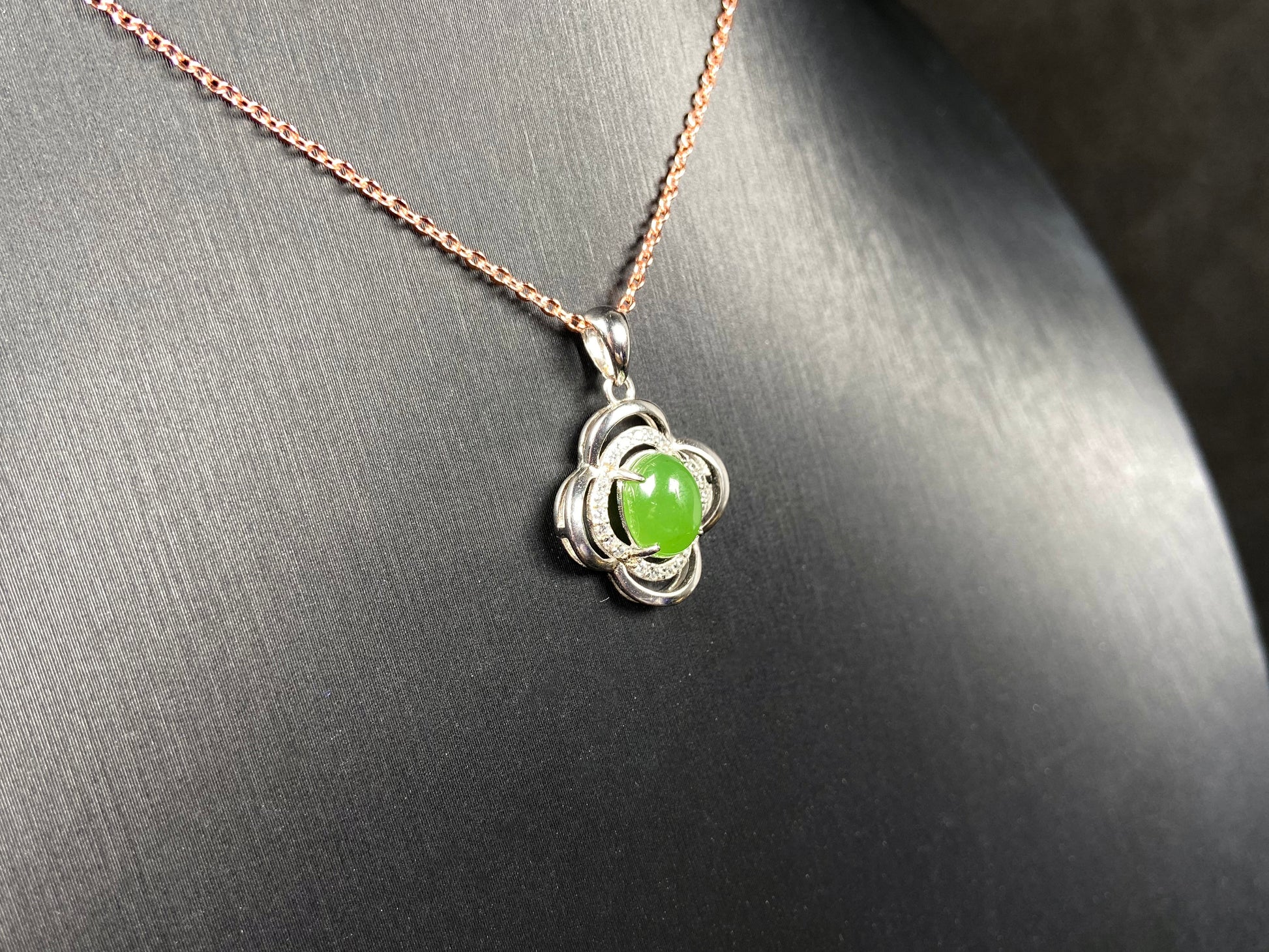 A vibrant clover green cabochon Hetian jade pendant.