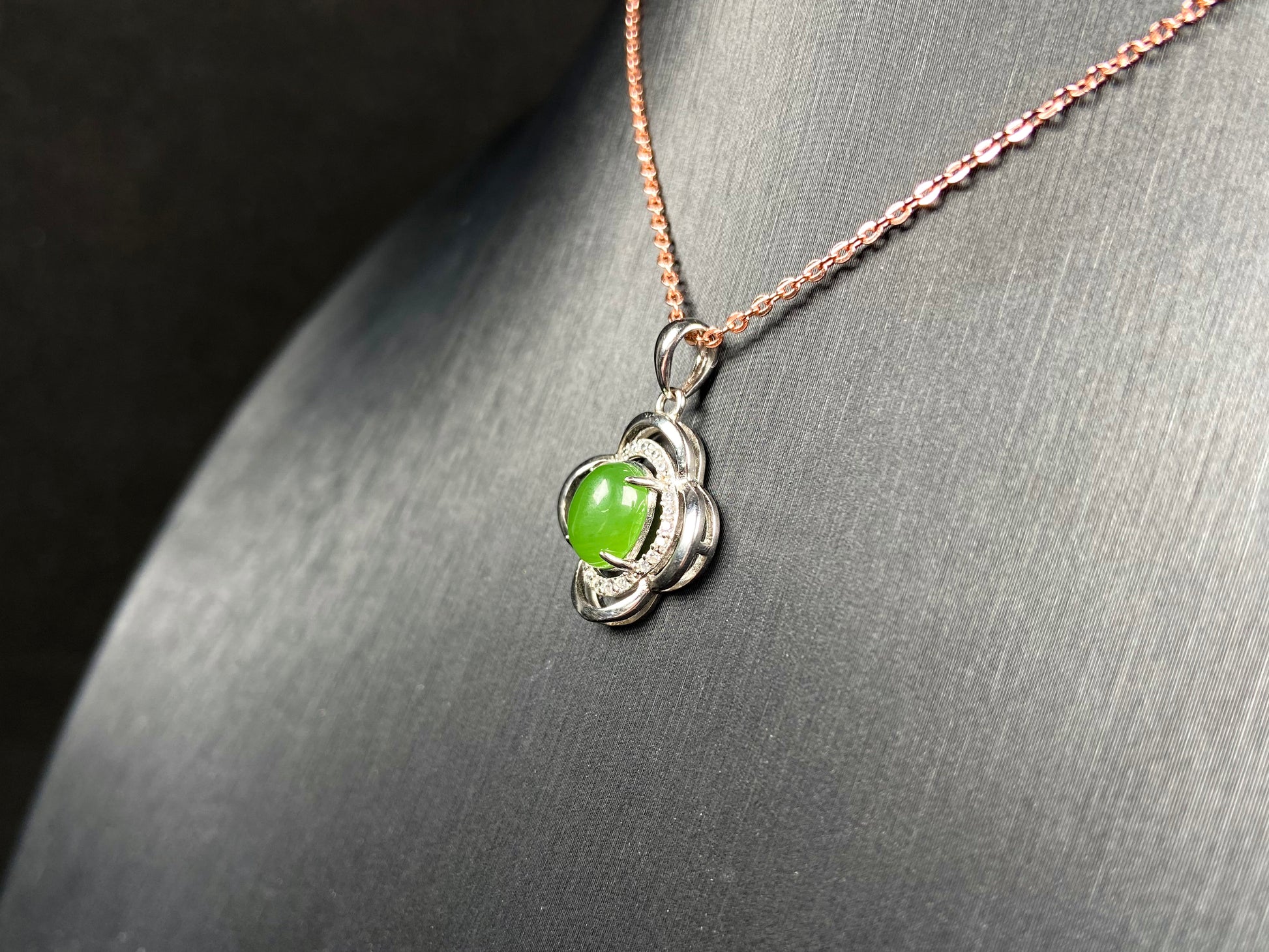 A vibrant clover green cabochon Hetian jade pendant.