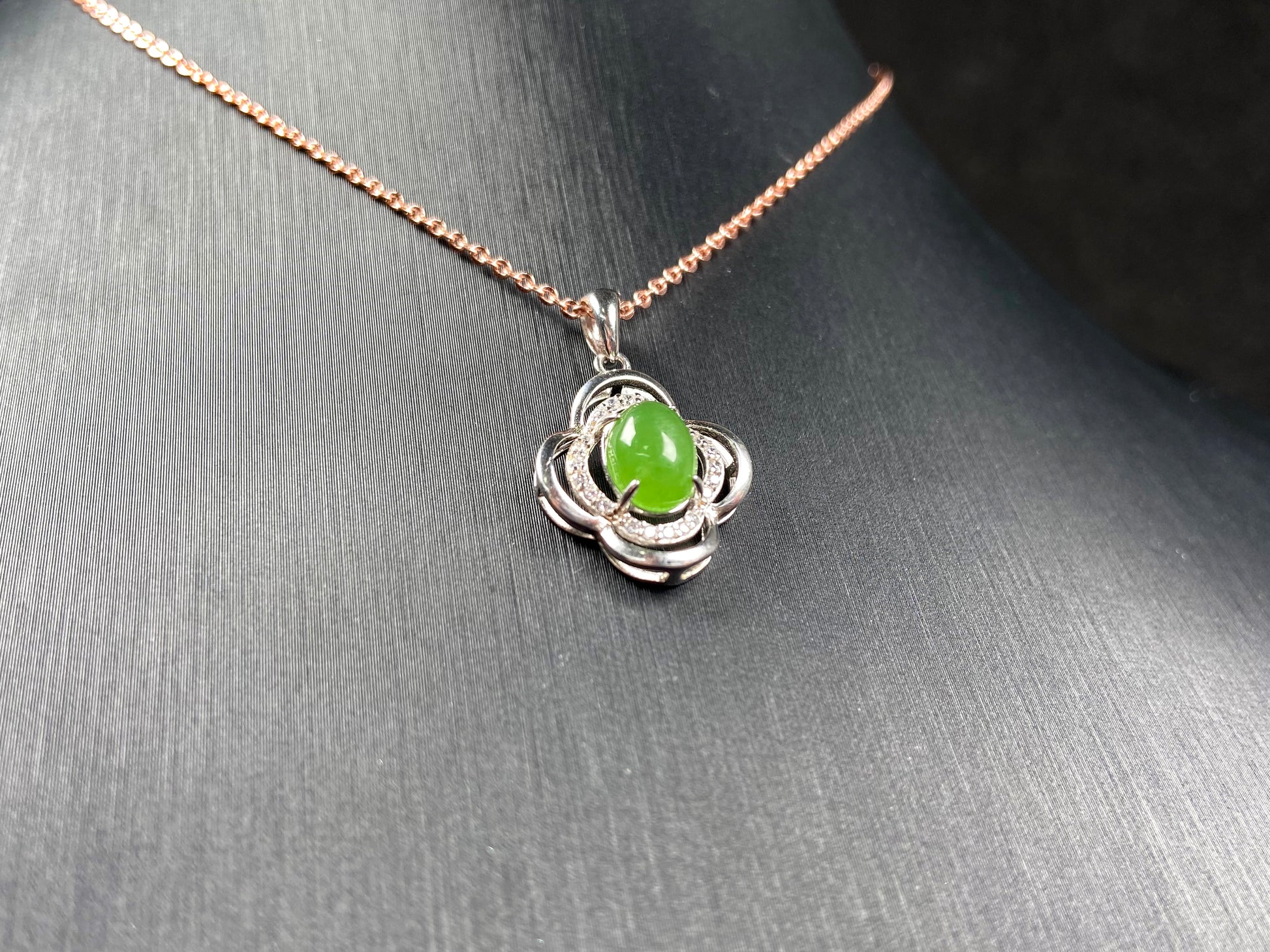 A vibrant clover green cabochon Hetian jade pendant.