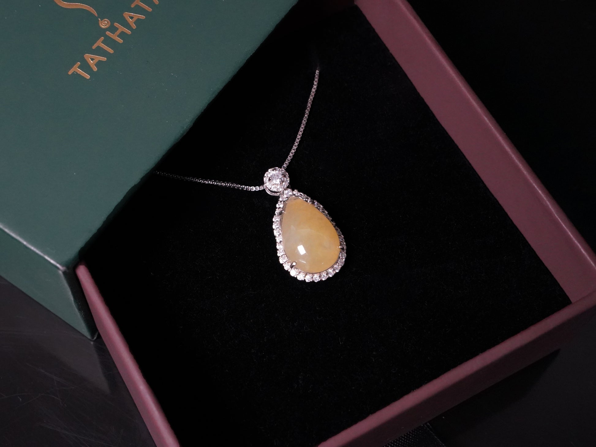 A pale yellow teardrop jadeite pendant.