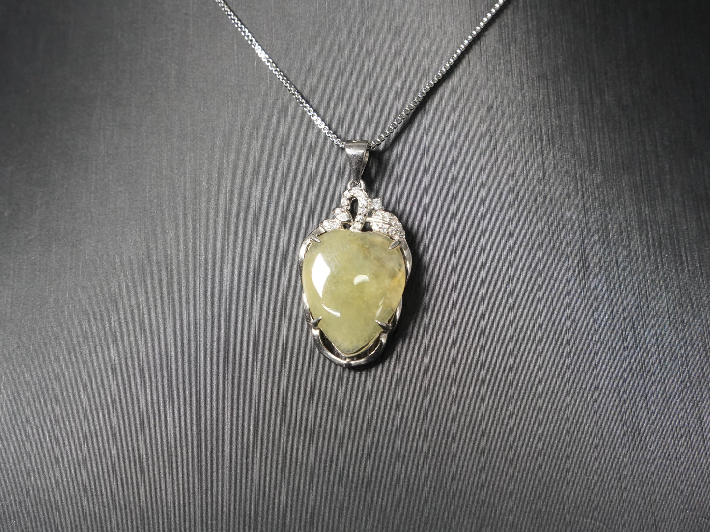A soft pale yellow heart jadeite pendant.