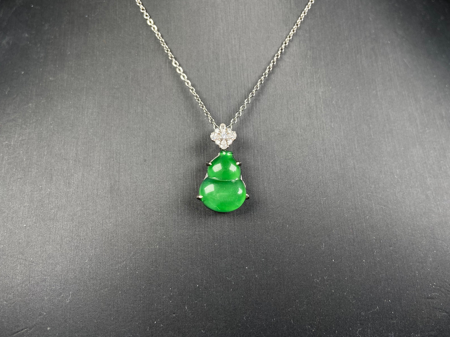 A diamond floral green hulu jadeite pendant.