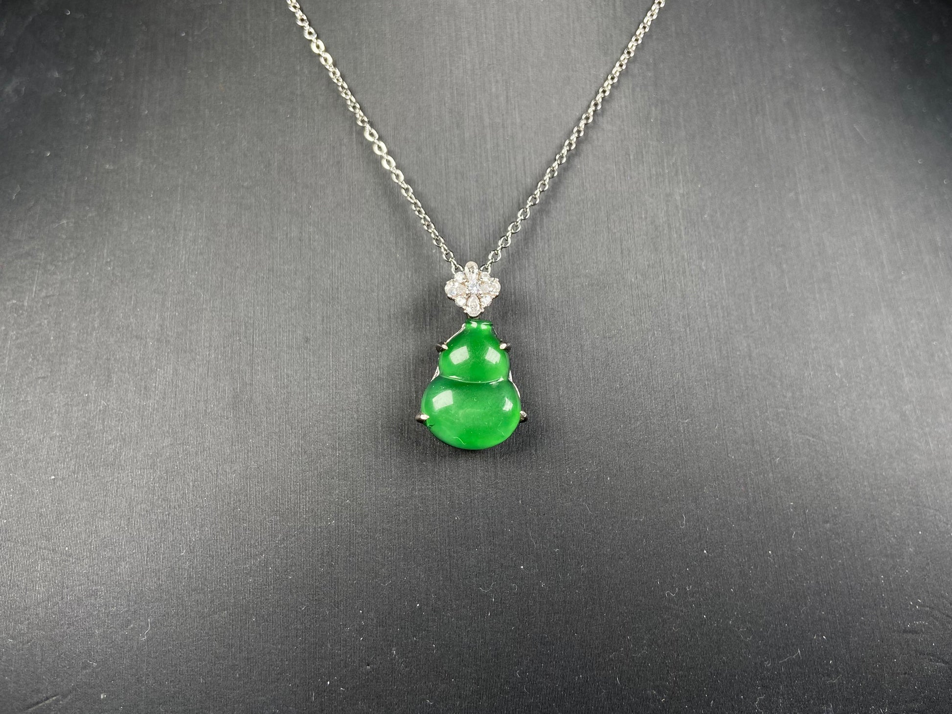 A diamond floral green hulu jadeite pendant.