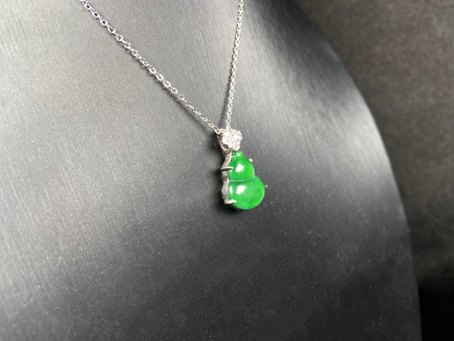 A diamond floral green hulu jadeite pendant.