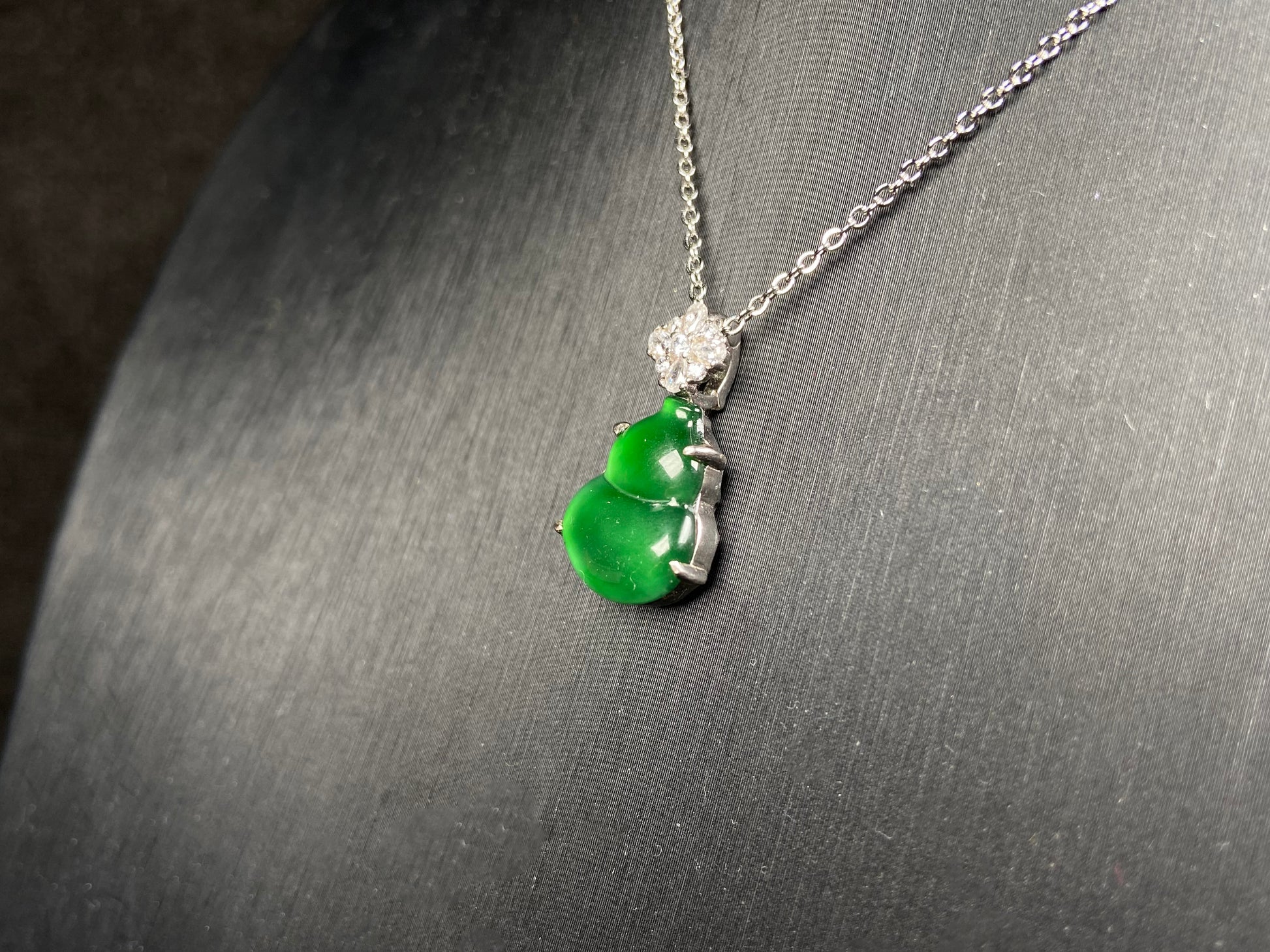 A diamond floral green hulu jadeite pendant.