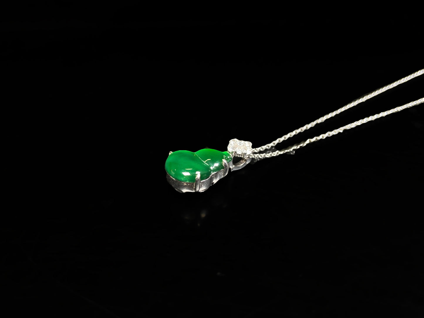 A diamond floral green hulu jadeite pendant.