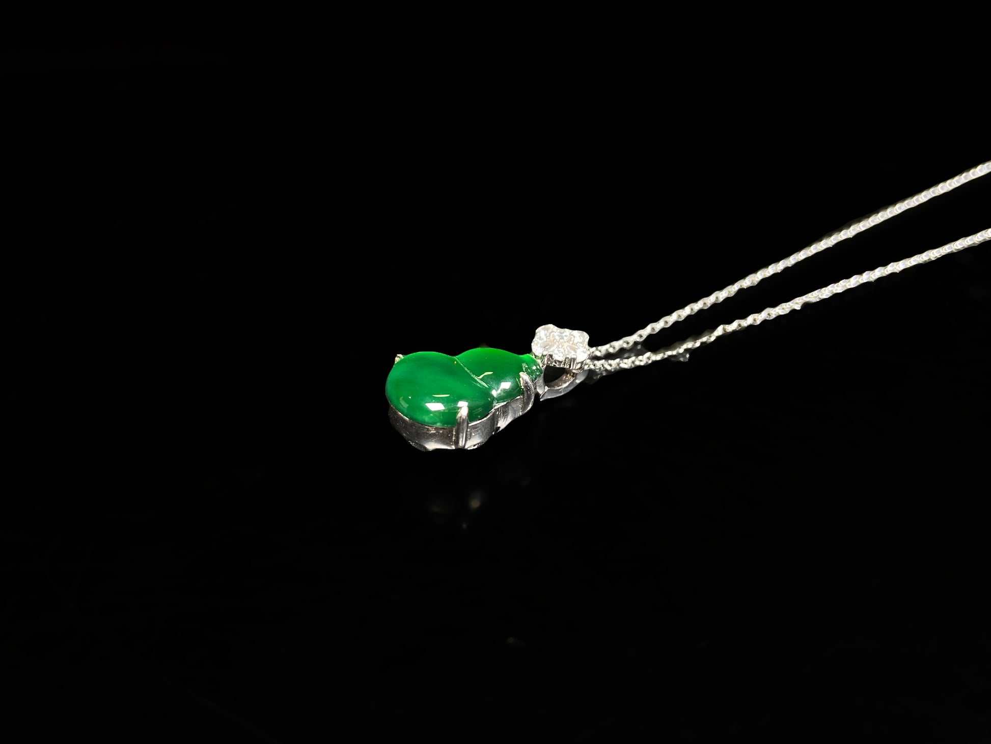 A diamond floral green hulu jadeite pendant.