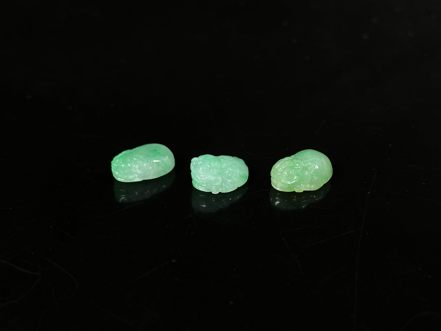 A three piece green toned pixiu set loose jadeite.
