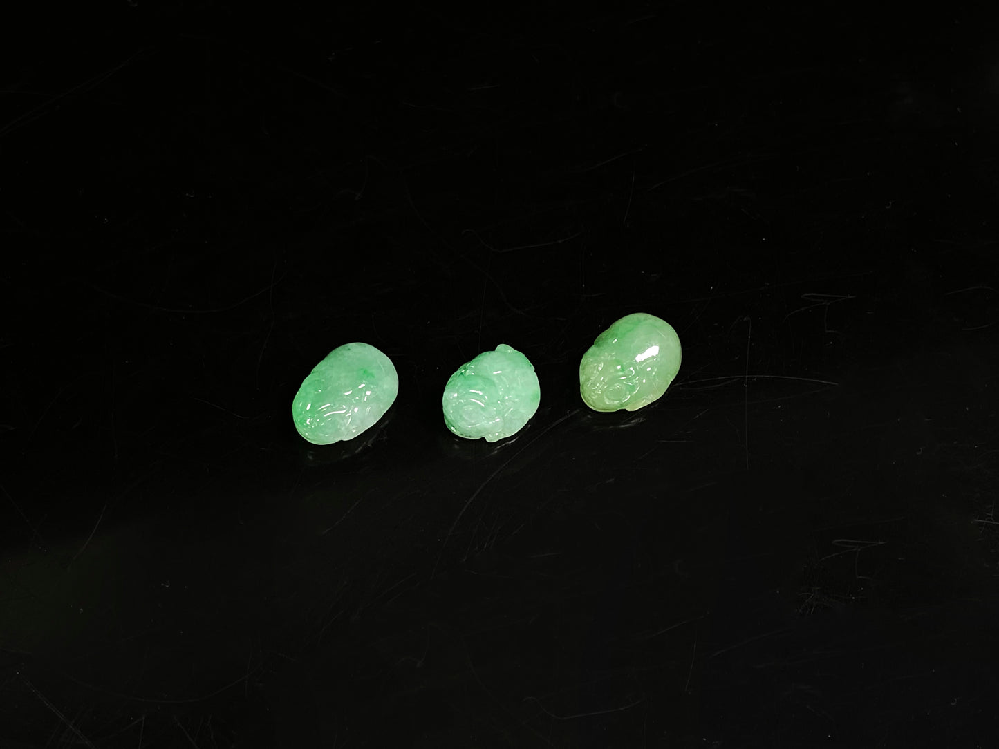 A three piece green toned pixiu set loose jadeite.