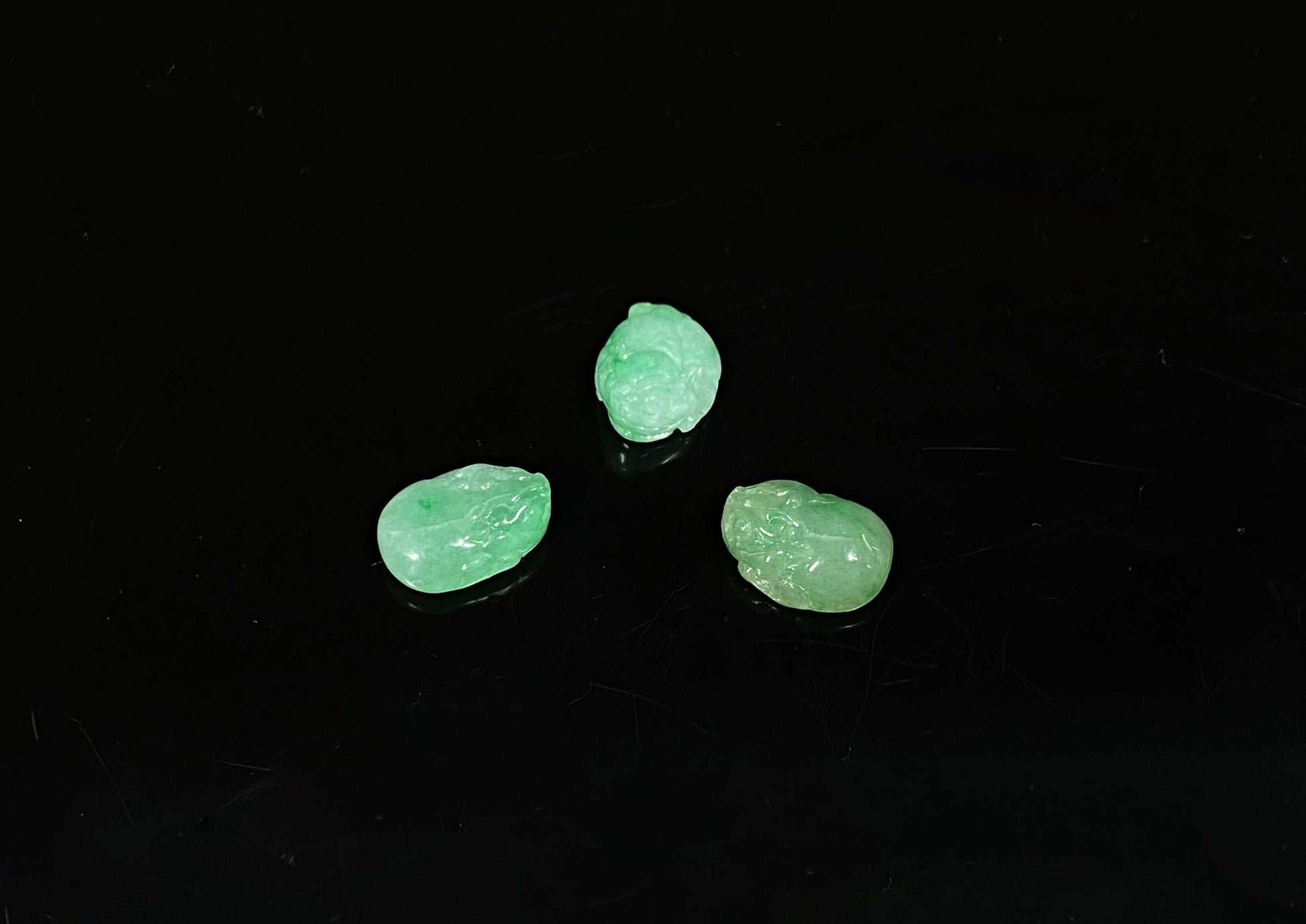 A three piece green toned pixiu set loose jadeite.