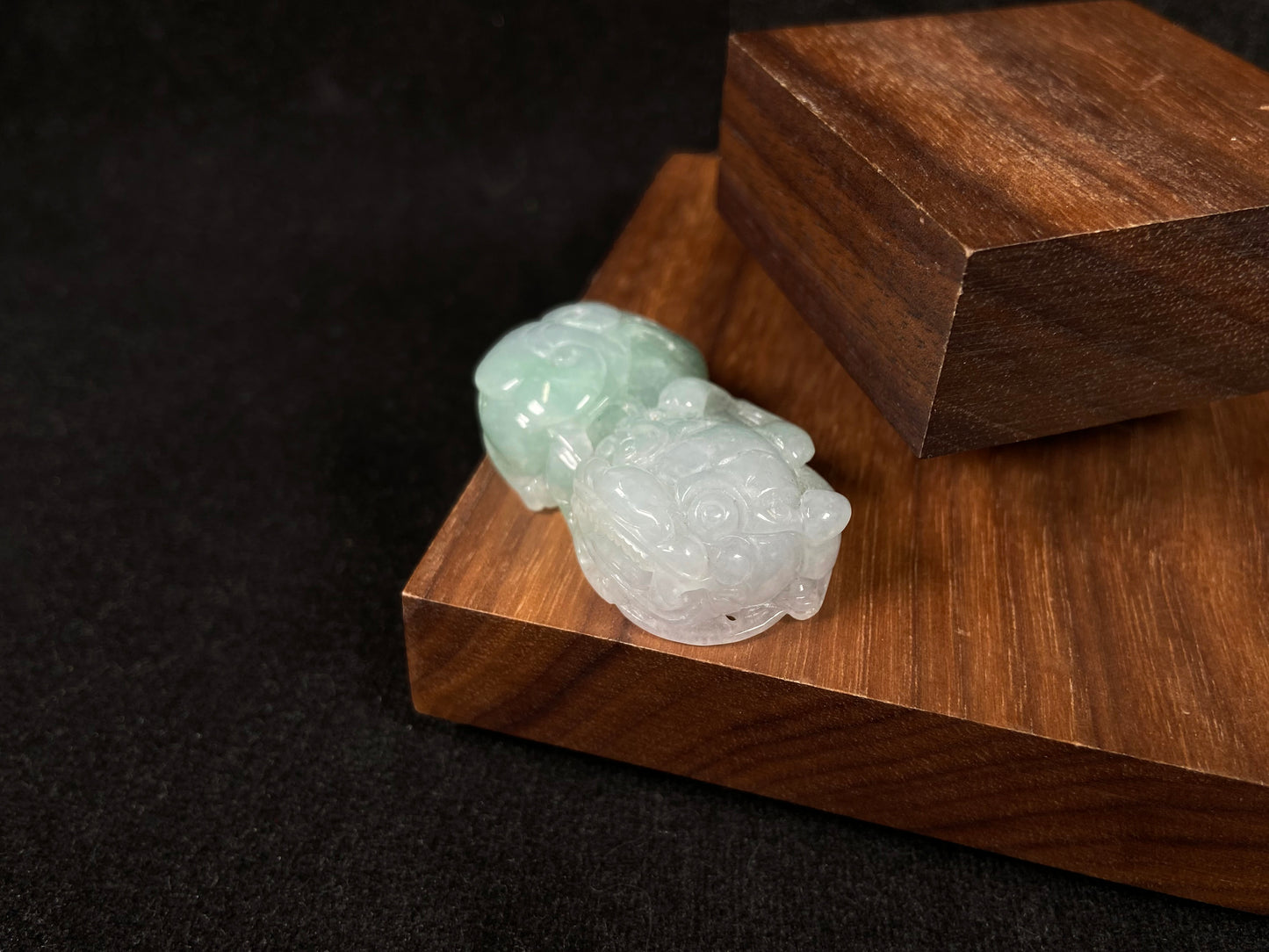 A Pi Xiu jadeite carving with a light green lower body and creamy white head.