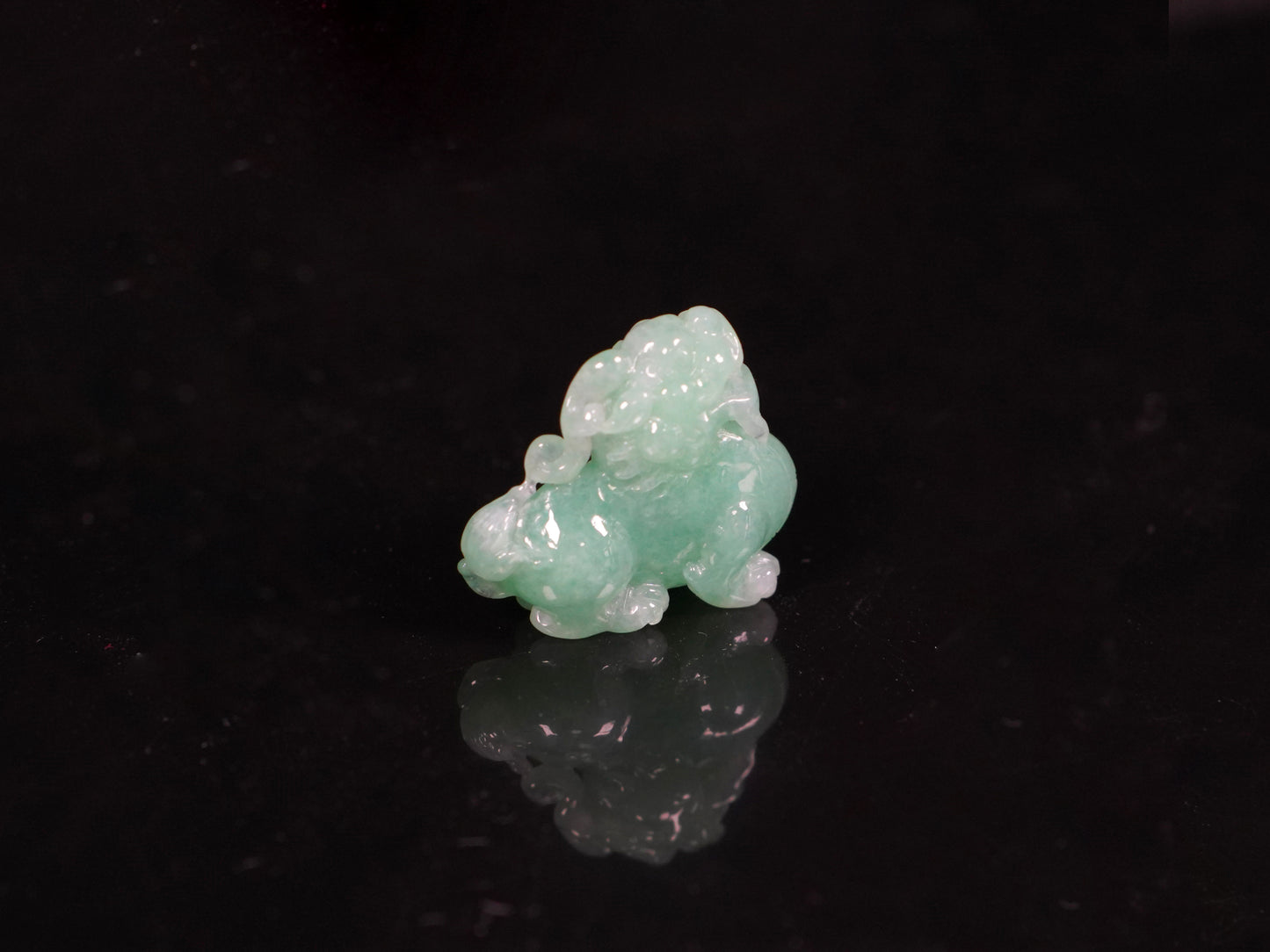 A luminous mint green Pixiu loose jadeite.