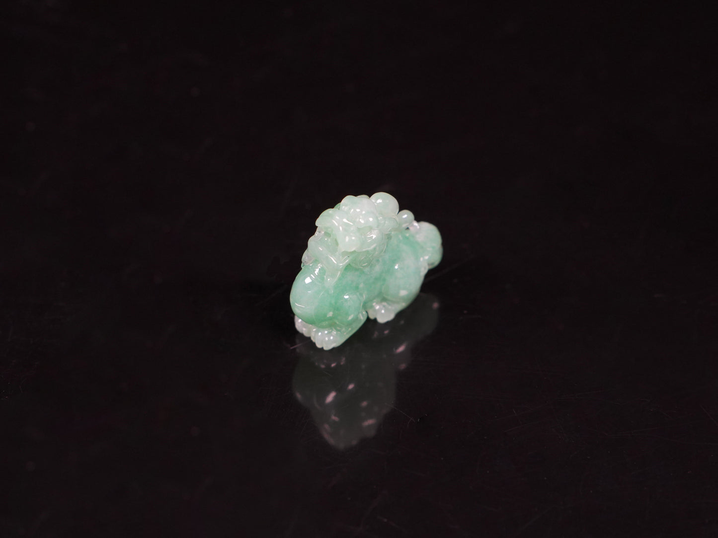 A luminous mint green Pixiu loose jadeite.