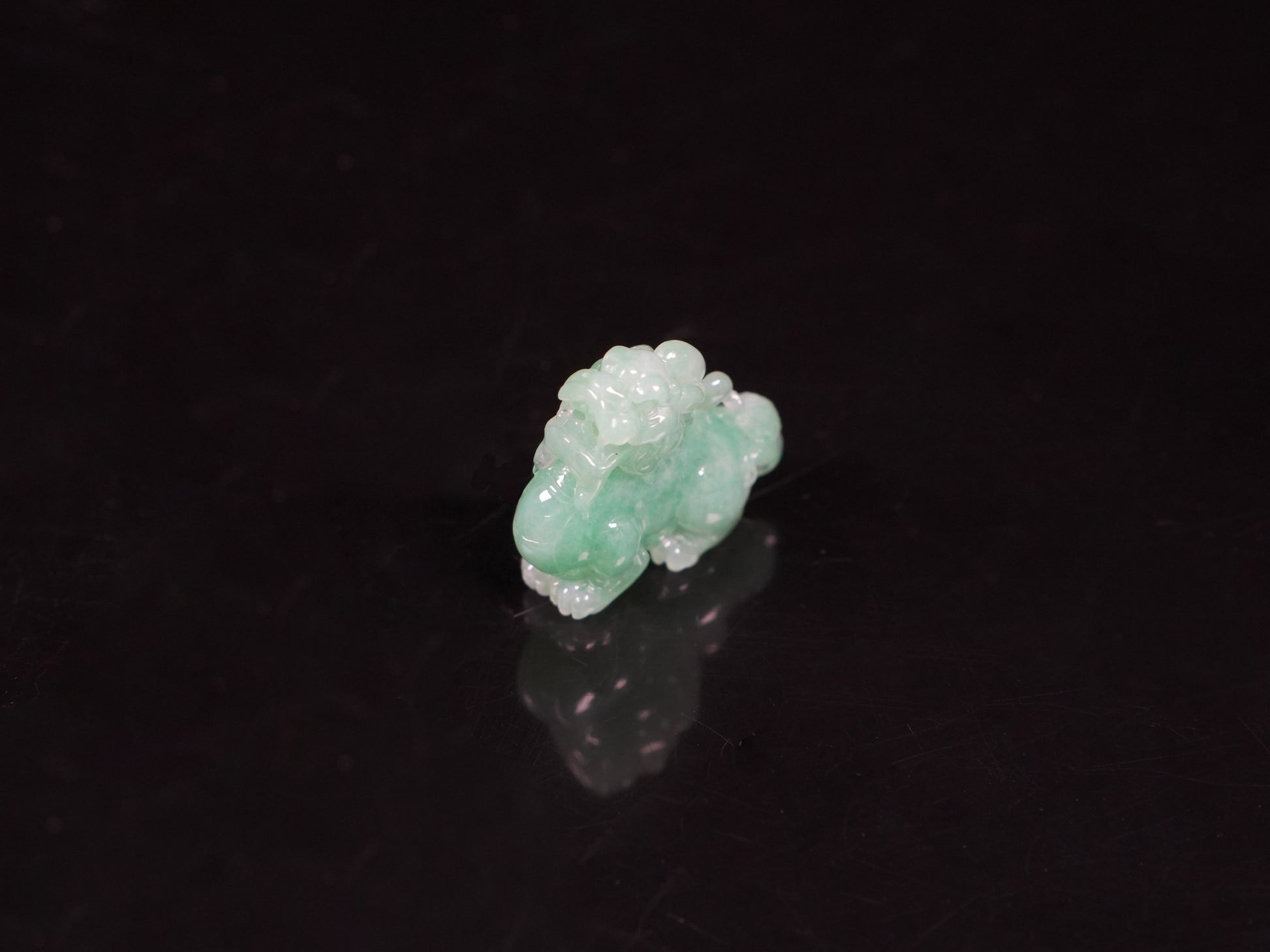 A luminous mint green Pixiu loose jadeite.