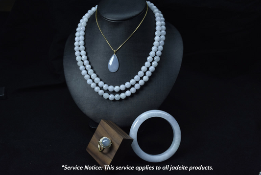 Jade necklace and bracelet on a black stand with a service notice at the bottom.
