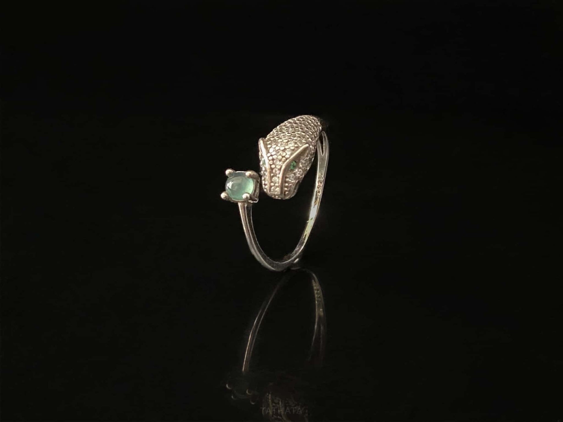 A silver serpent bite jadeite ring.