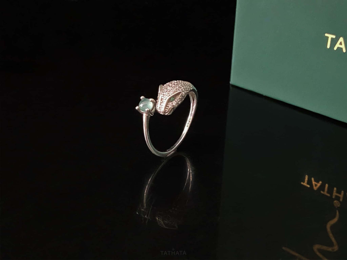 A silver serpent bite jadeite ring.