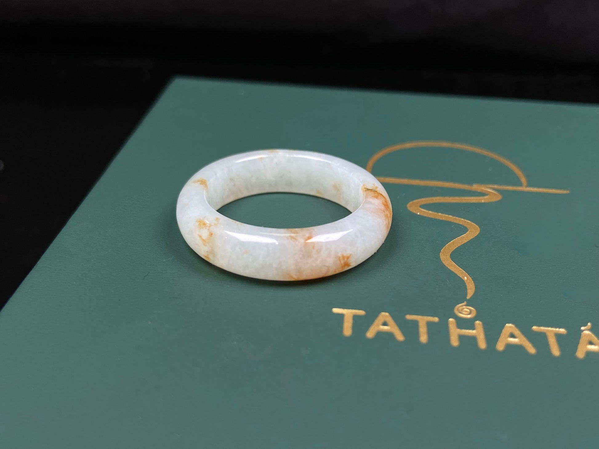 A misty white with amber fleck jadeite ring.