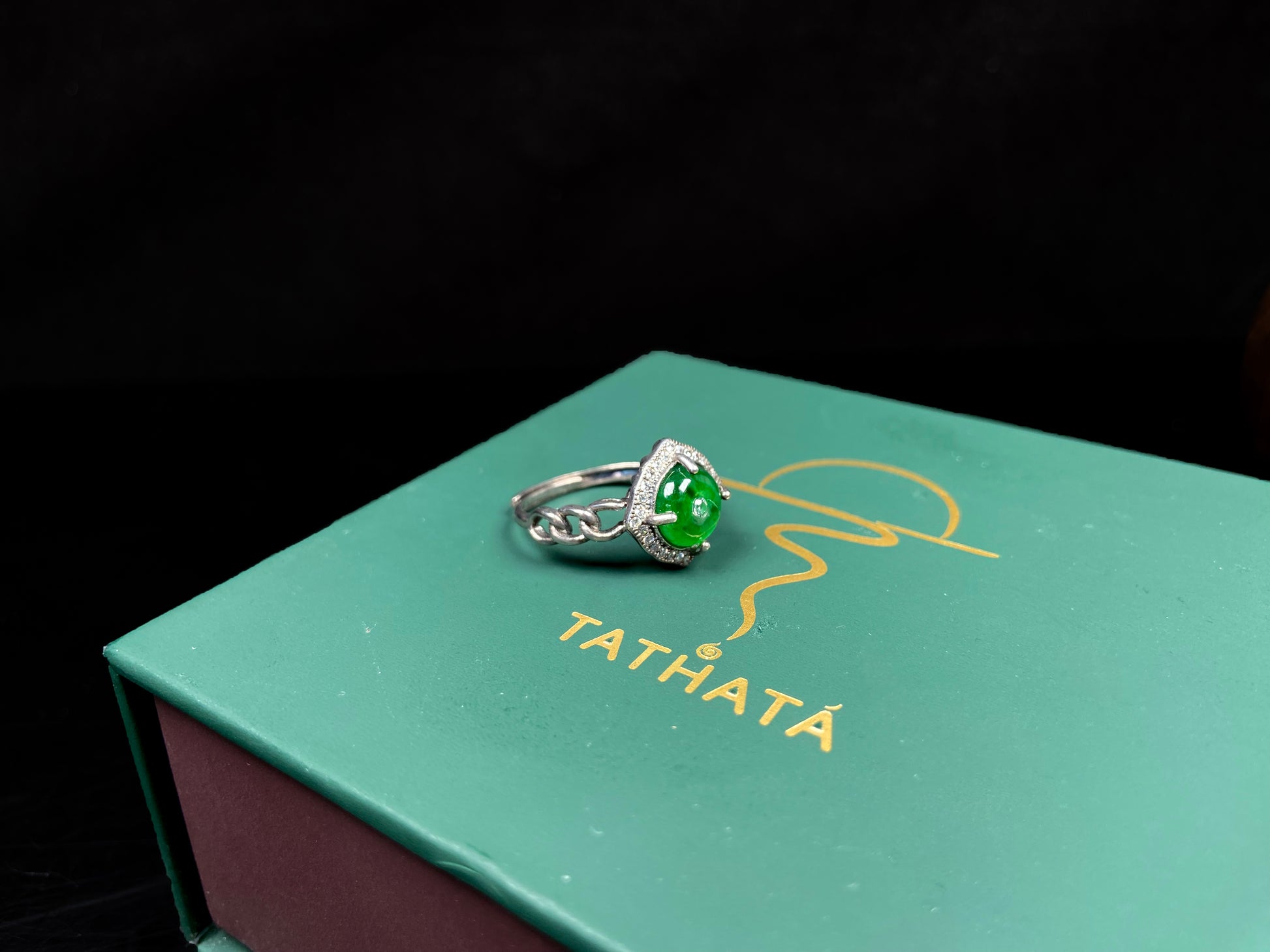 A curb chain green jadeite ring.