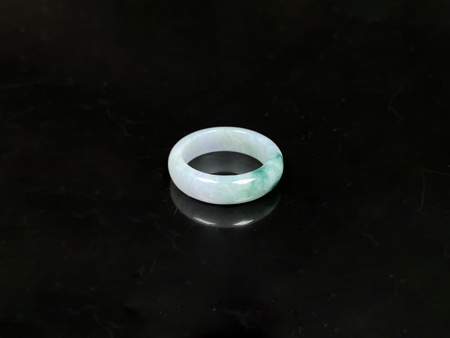 A milky white with green veins jadeite ring.