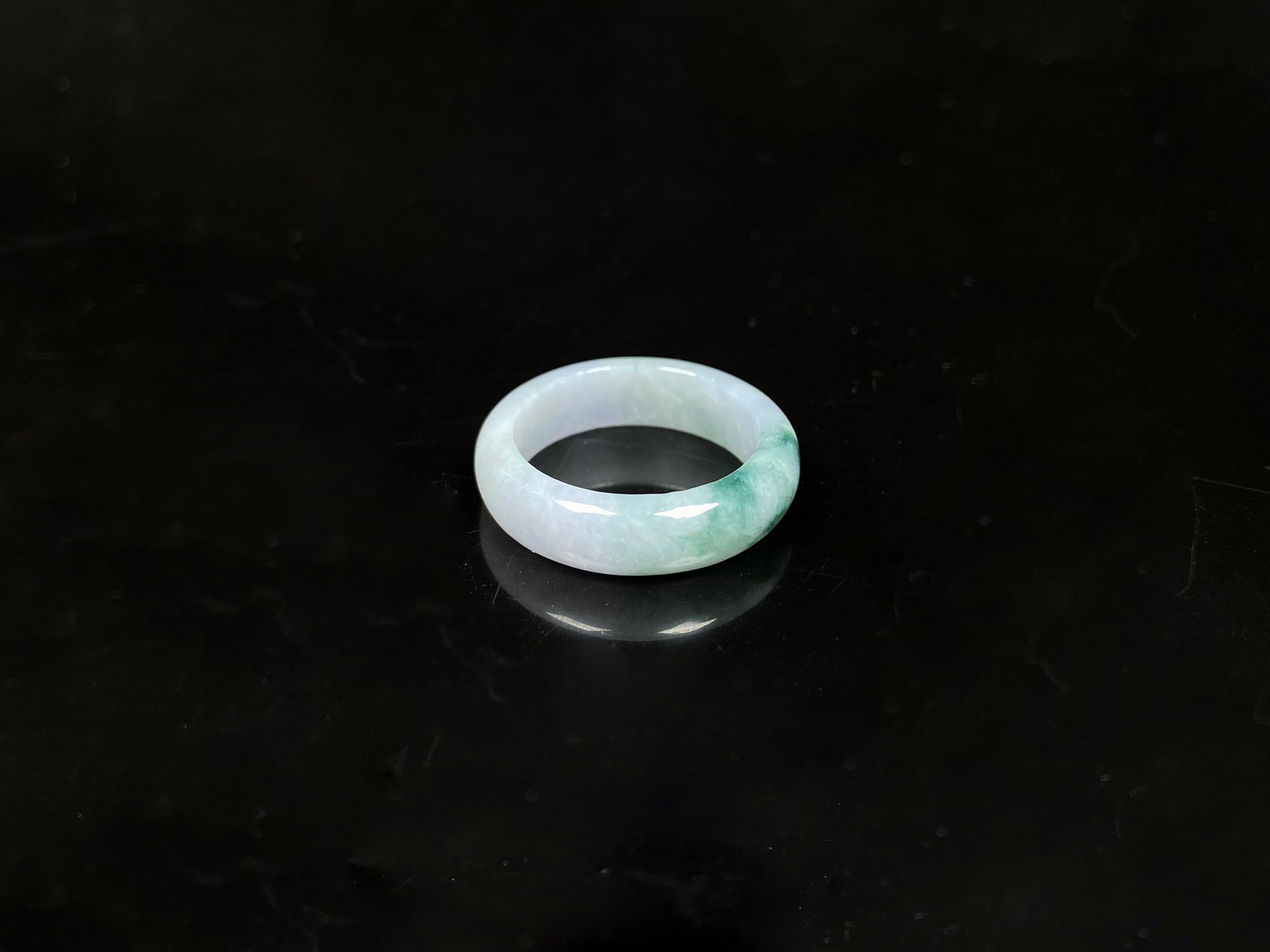 A milky white with green veins jadeite ring.