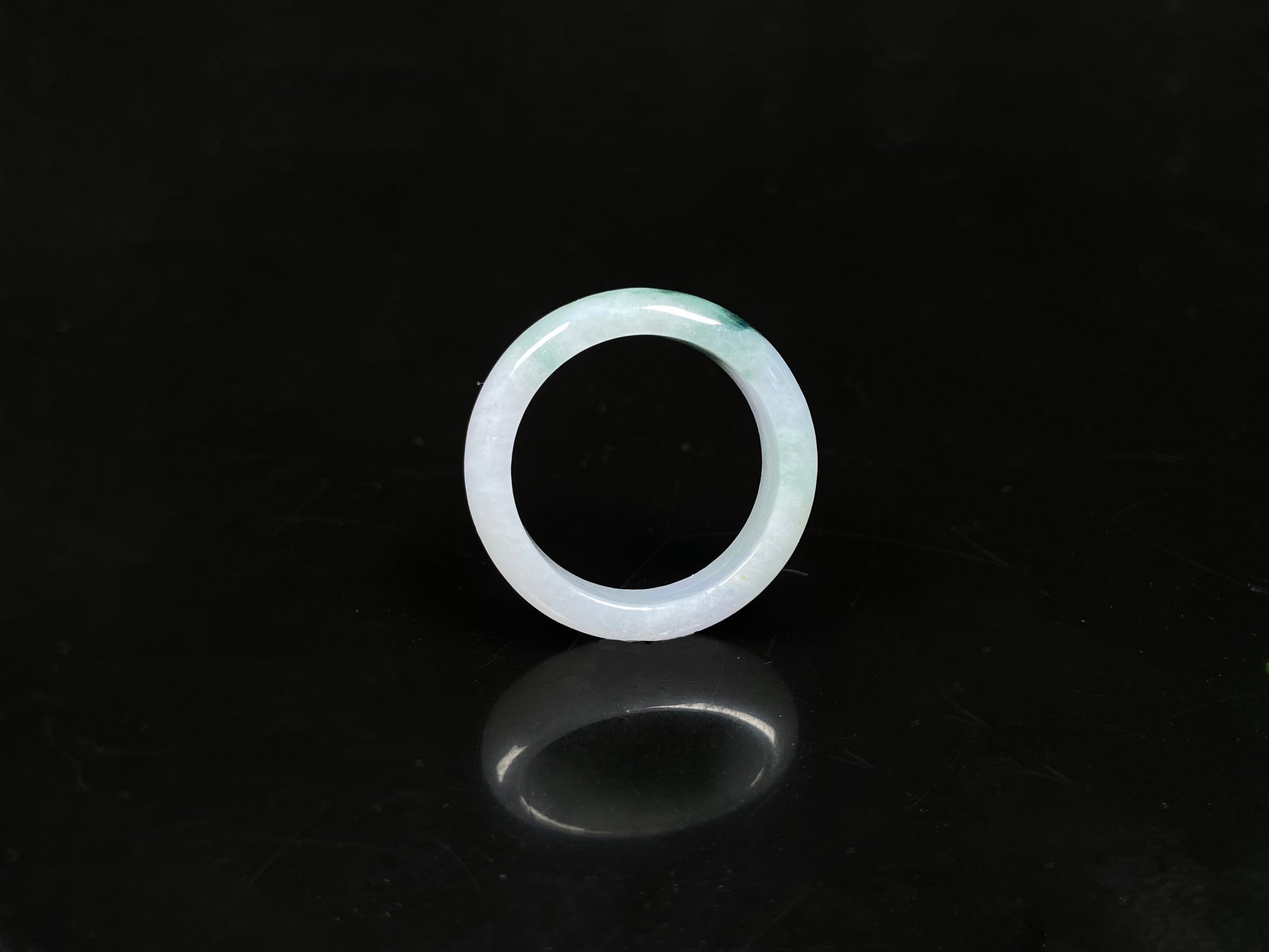 A milky white with green veins jadeite ring.
