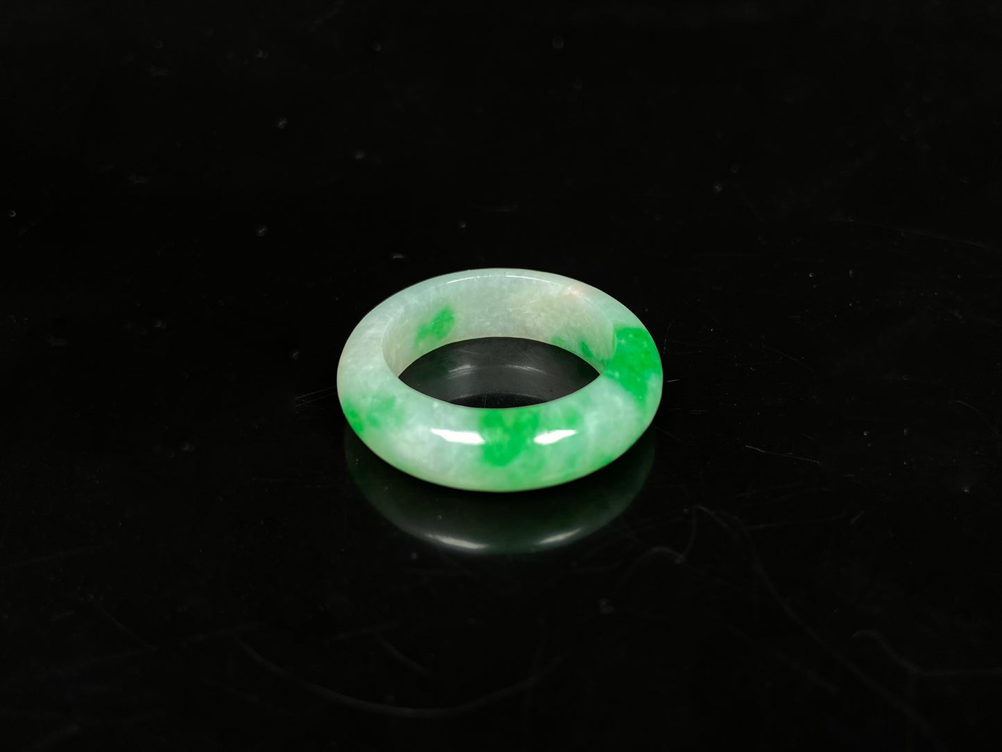 A lush green patch on white jadeite ring.