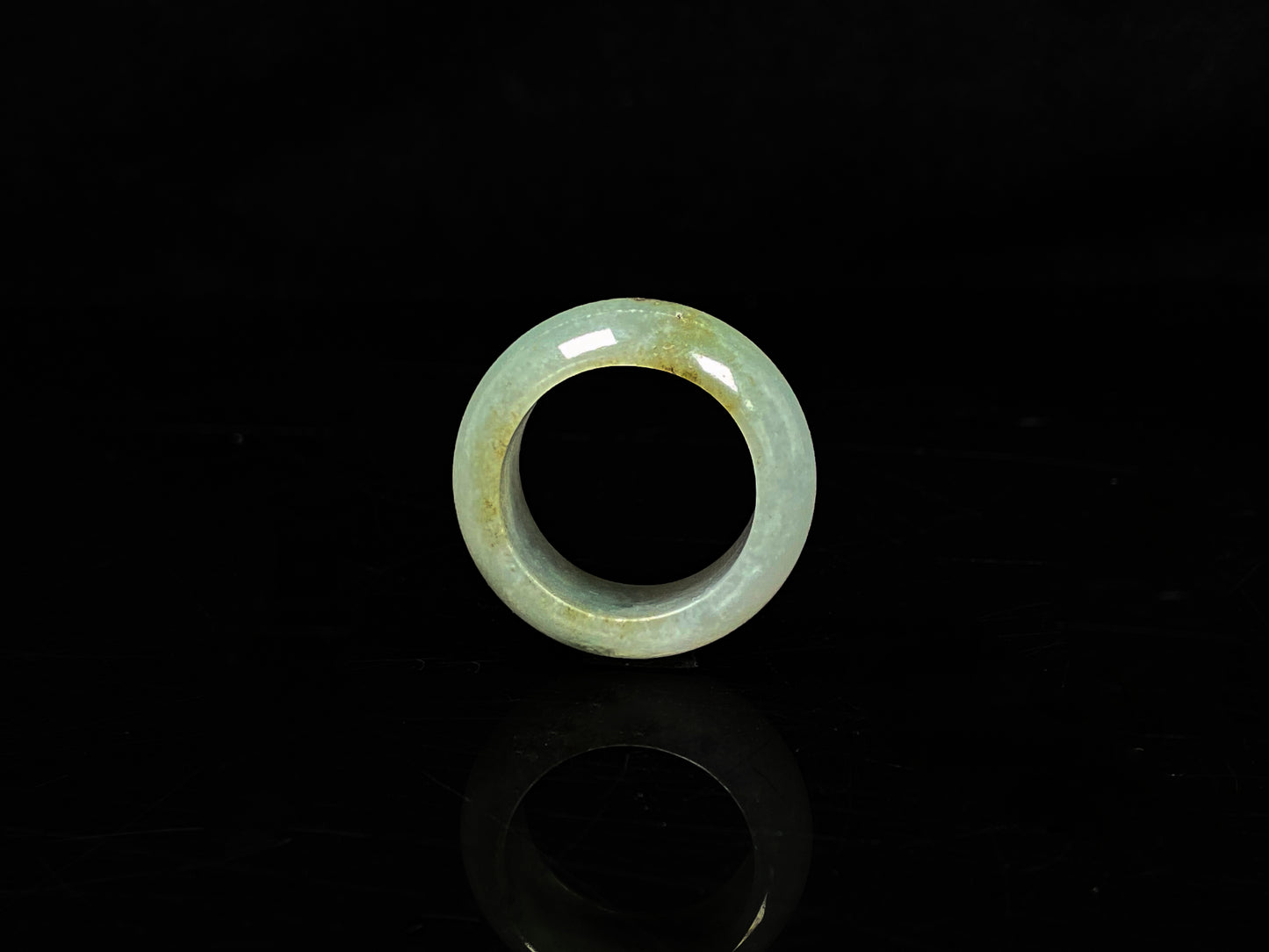 A pale verdant with golden dots jadeite ring.