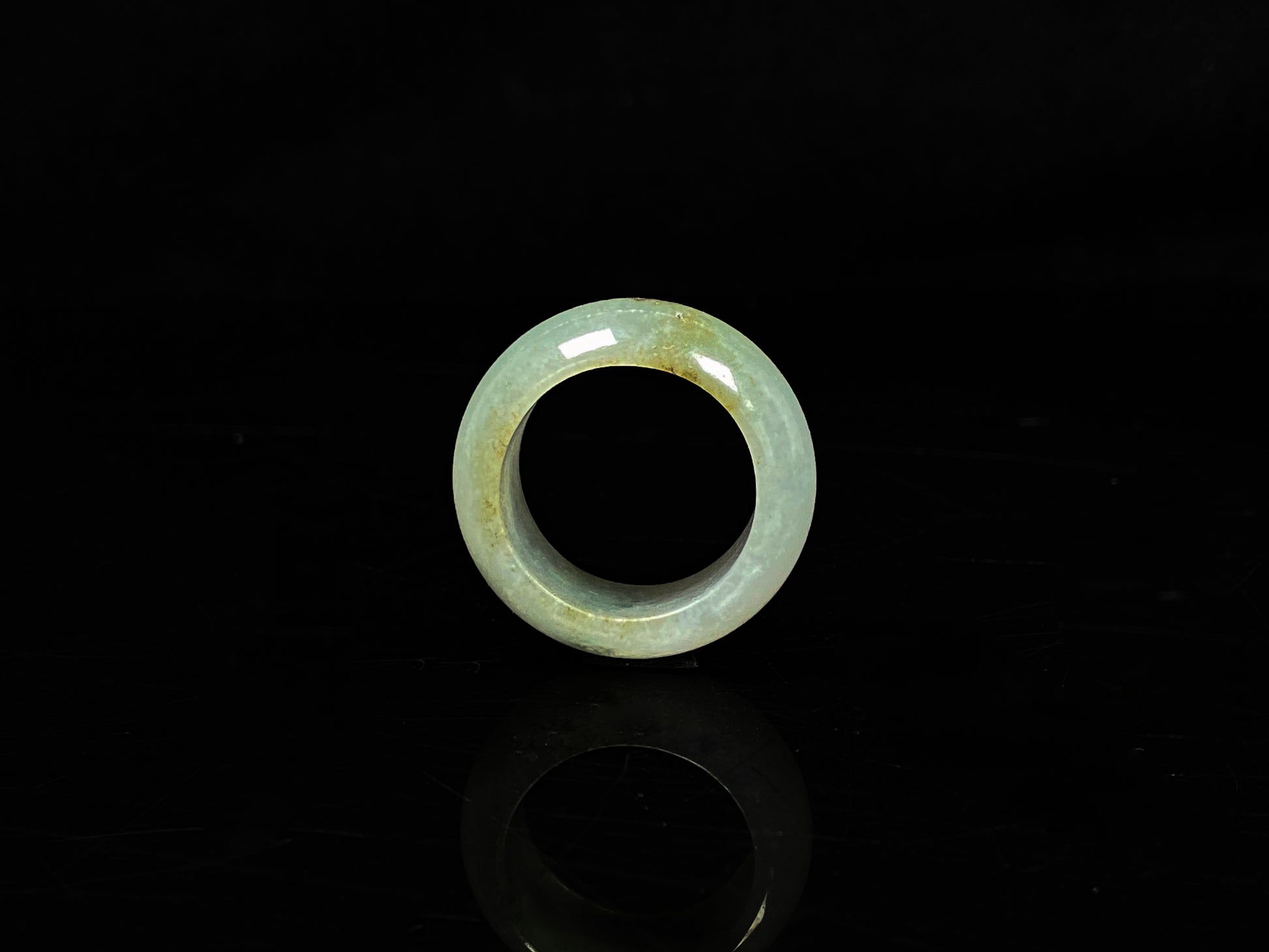 A pale verdant with golden dots jadeite ring.