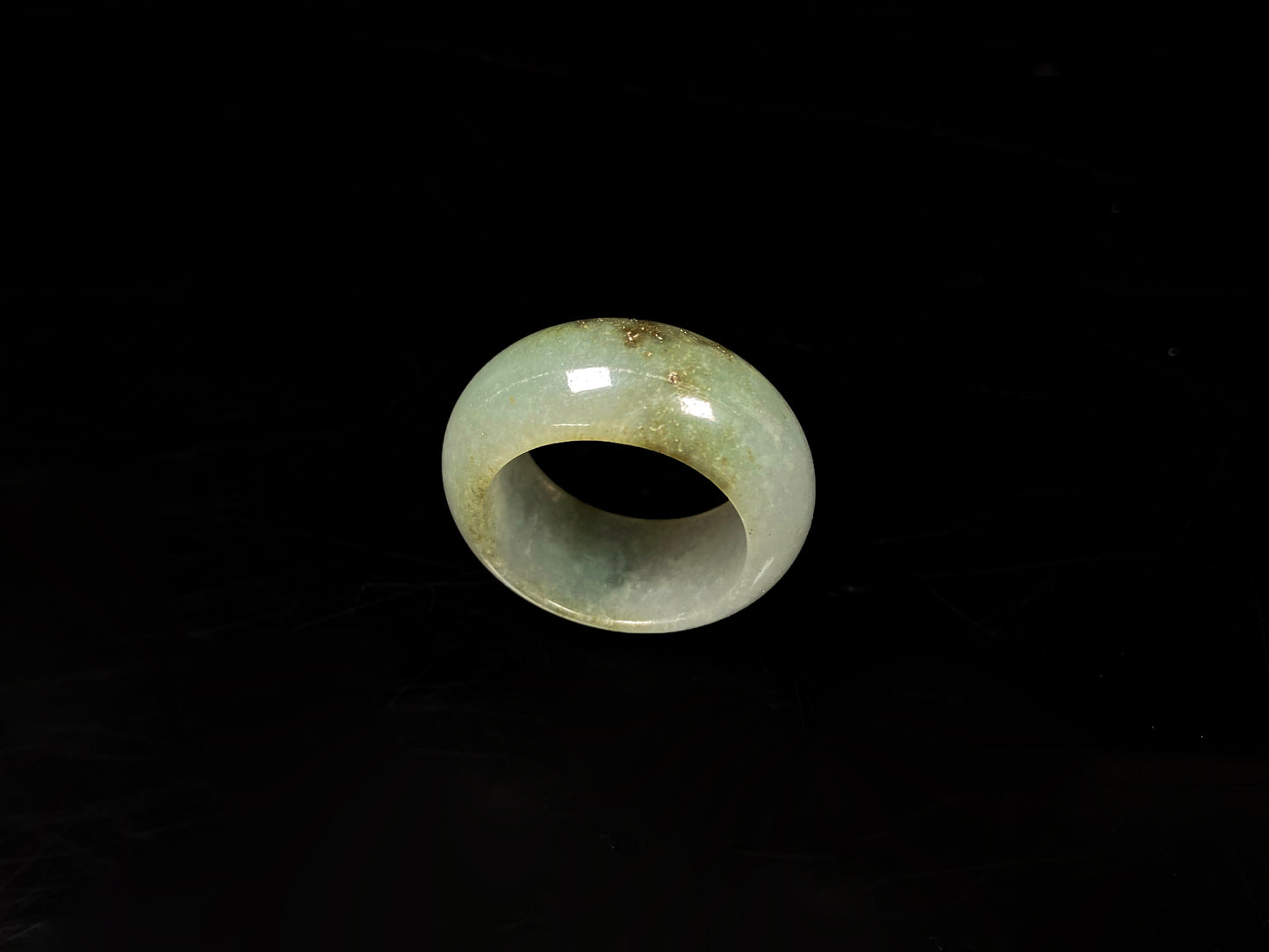 A pale verdant with golden dots jadeite ring.