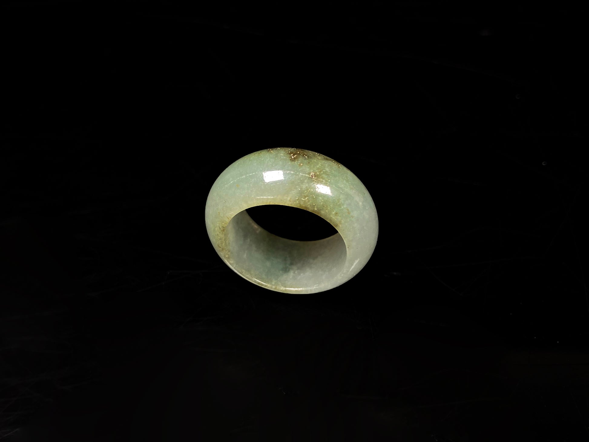 A pale verdant with golden dots jadeite ring.