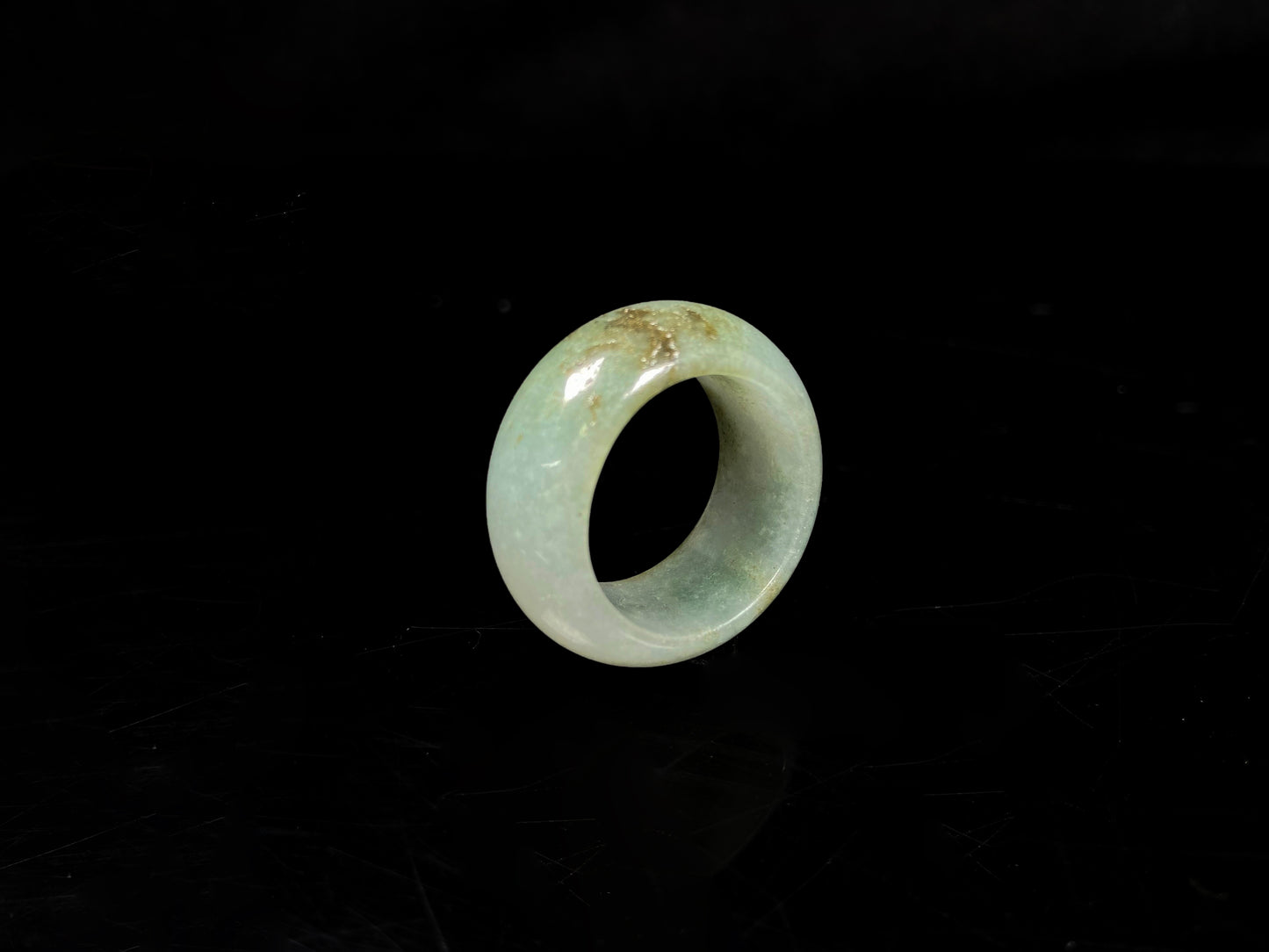 A pale verdant with golden dots jadeite ring.