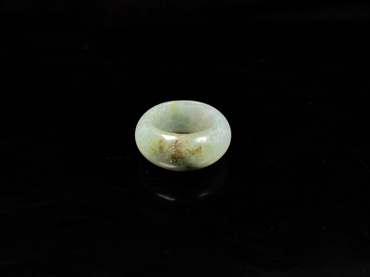 A pale verdant with golden dots jadeite ring.