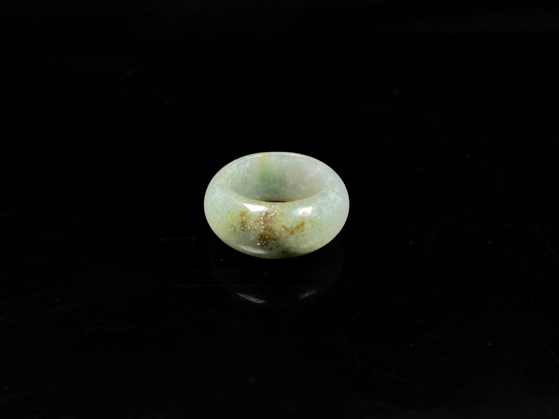 A pale verdant with golden dots jadeite ring.