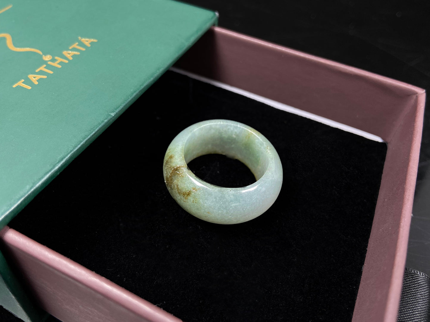A pale verdant with golden dots jadeite ring.