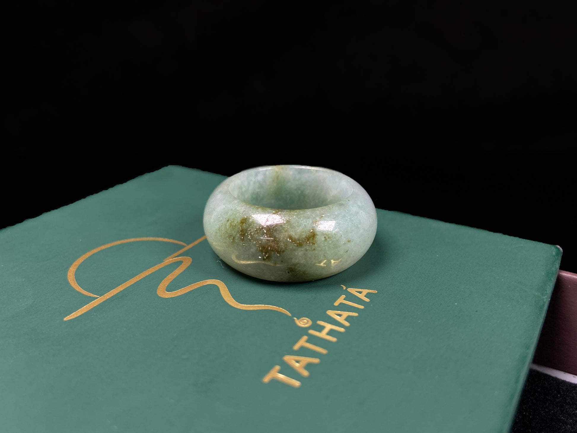 A pale verdant with golden dots jadeite ring.