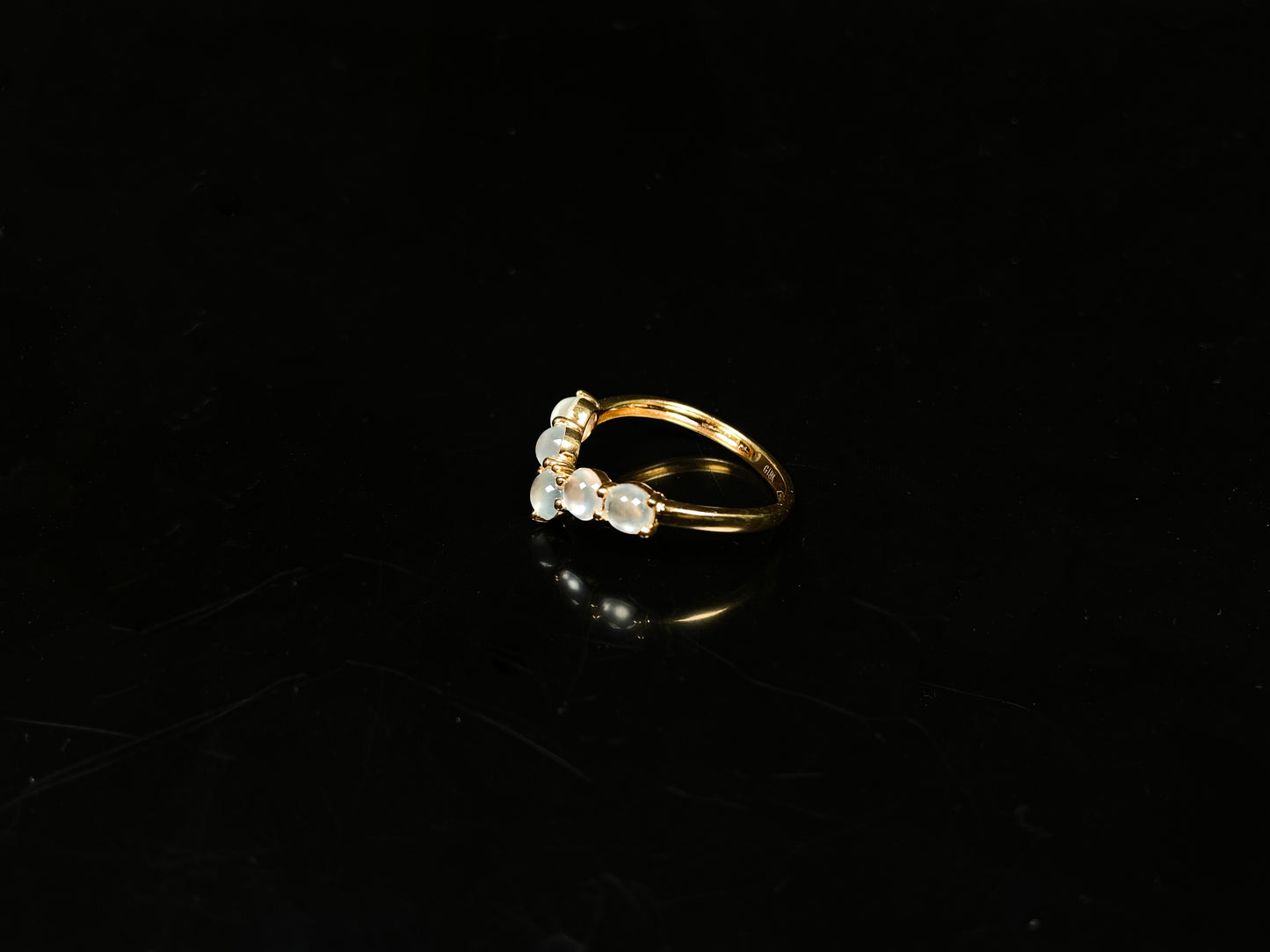 A clear bead cluster crown on gold jadeite ring.