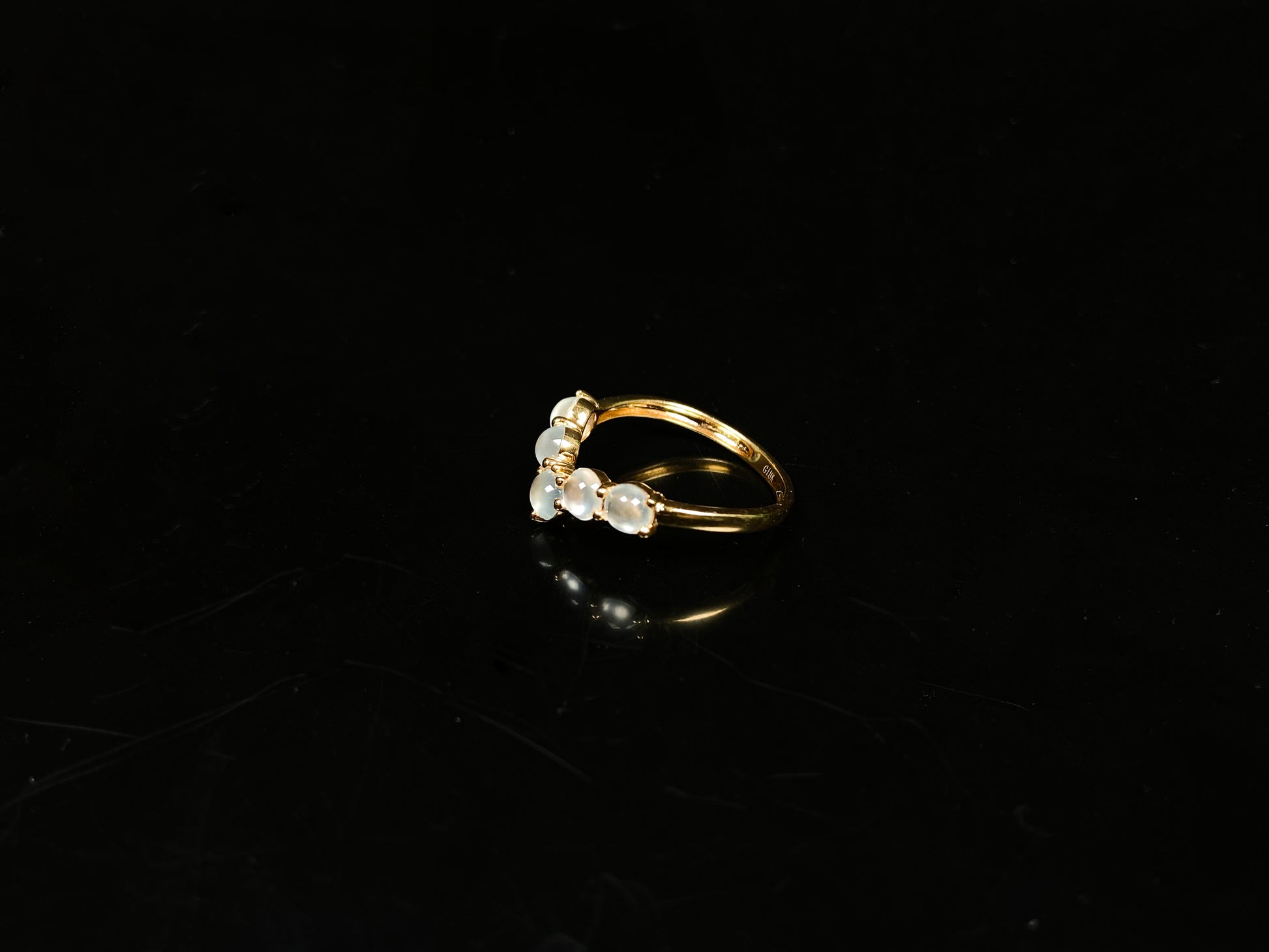 A clear bead cluster crown on gold jadeite ring.