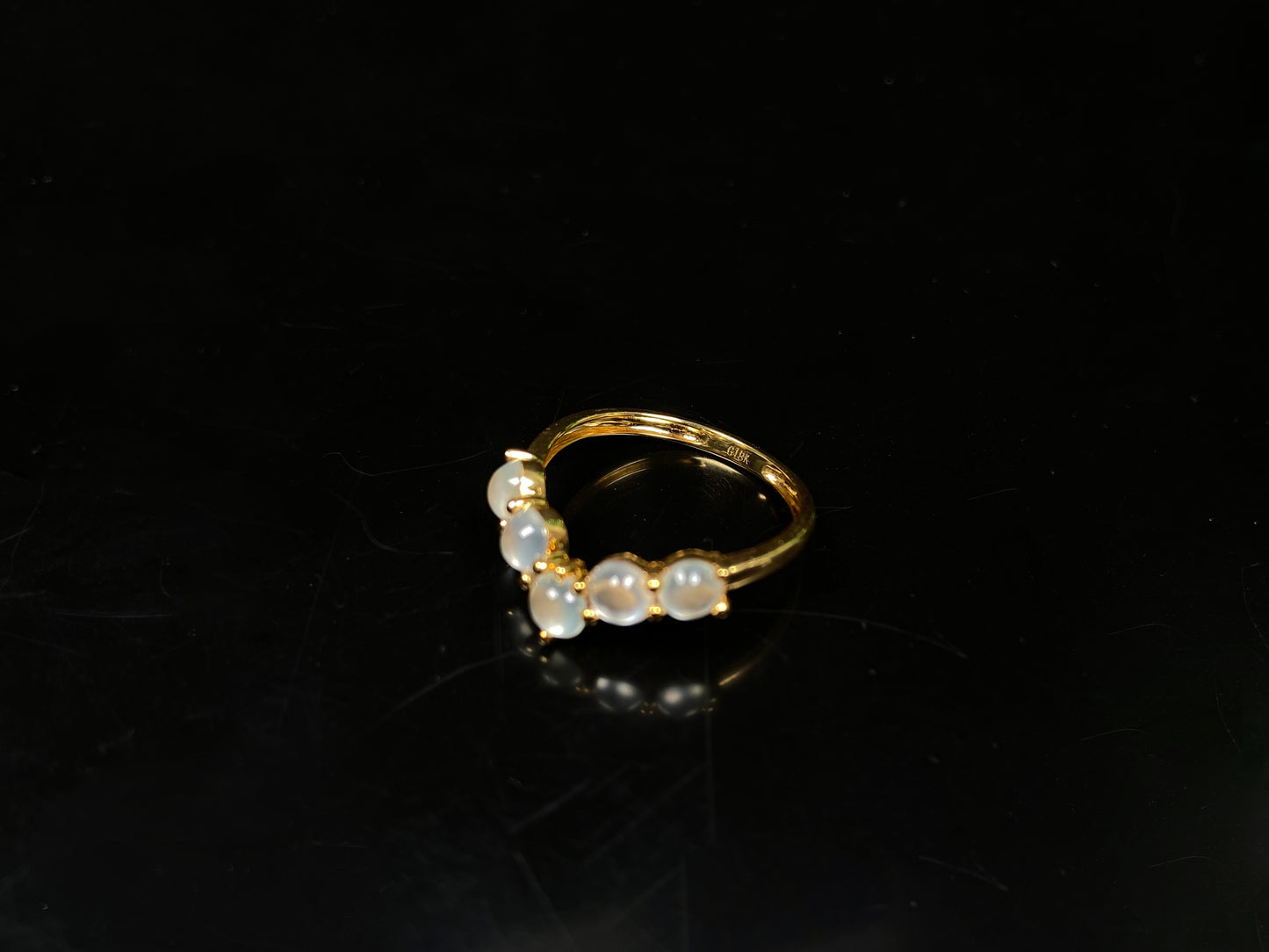 A clear bead cluster crown on gold jadeite ring.